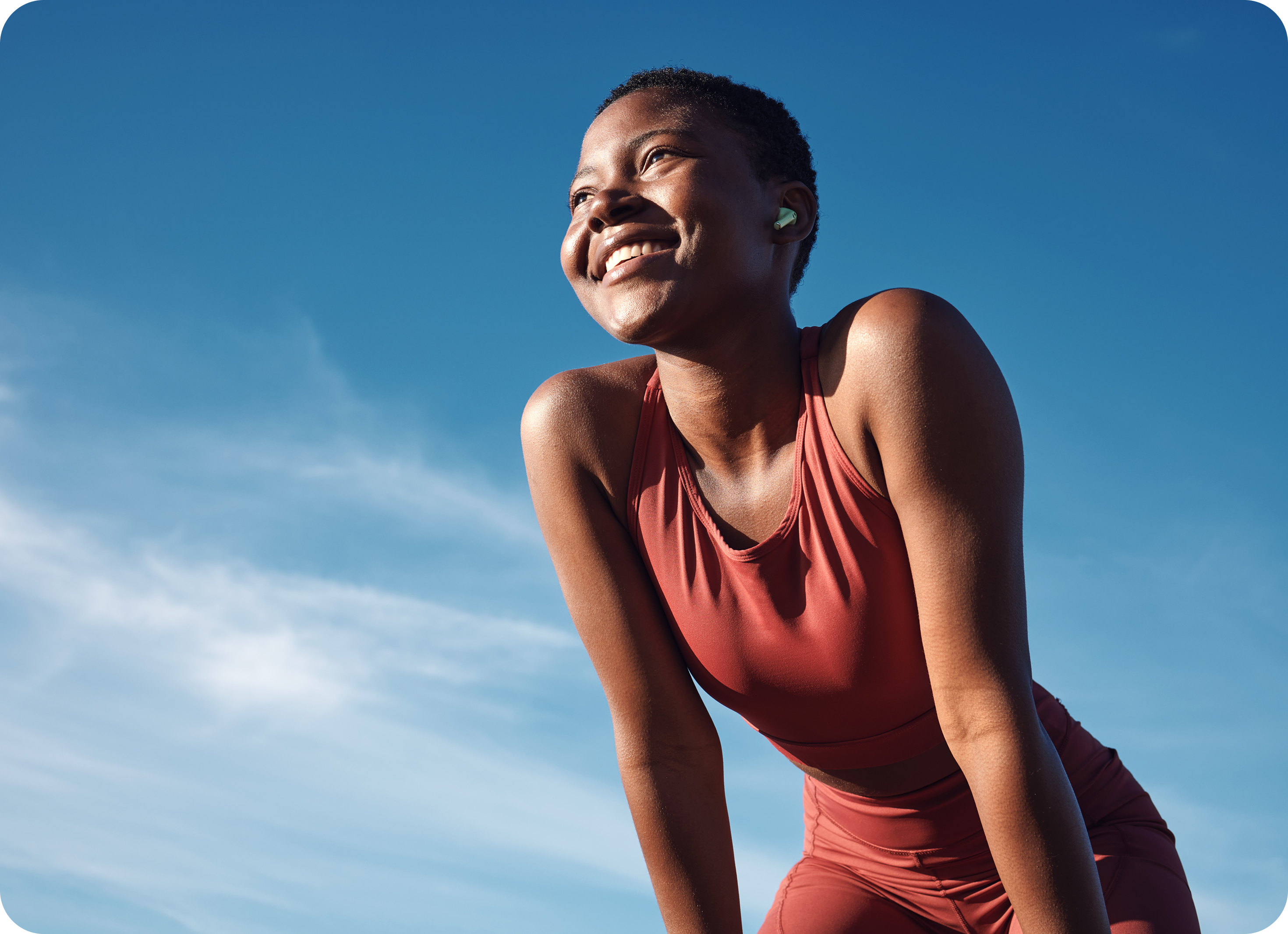 Woman in red athletic outfit against a blue sky